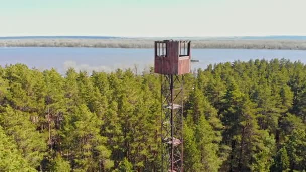 Högt landmärke torn byggnad i skogen - en pråm segel på bakgrunden — Stockvideo
