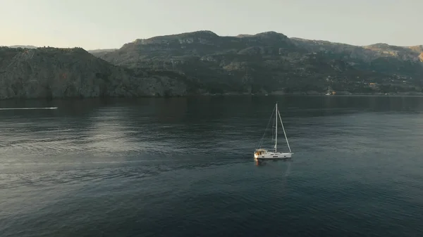 Aerial View of yacht near rocky island of Mallorca. Drone footage of yachting around Balearic islands in the mediterranean sea