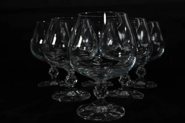 Koyu arkaplanda altı berrak kristal bardak.