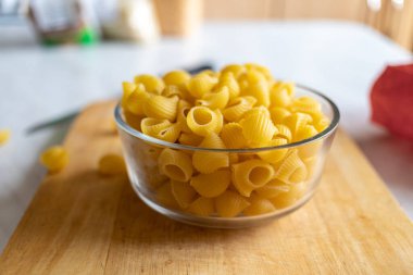 Sarı kuru bezelyeler ahşap bir tahtaya saçılmış. Yanında bezelye kabı da var. Masa ve tahta tahta mutfak. ham.