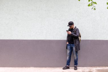 Siyah yağmurluk, şapka ve gözlük takan yakışıklı bir adam.. 