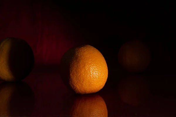 Koyu kırmızı arka planda parlak turuncu. İkinci portakal sadece hafif çizilmiş. Kompozisyonu tamamlıyor. Yansımalar.