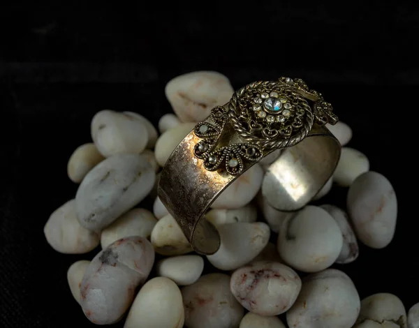 Bijouterie. Een glimmende armband gemaakt van rond staal met stenen in het midden — Stockfoto