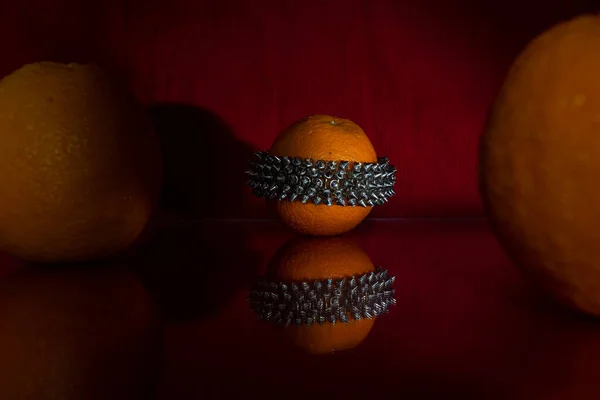 Det är Bijouterie. Ett armband, apelsiner och mörkröd bakgrund — Stockfoto