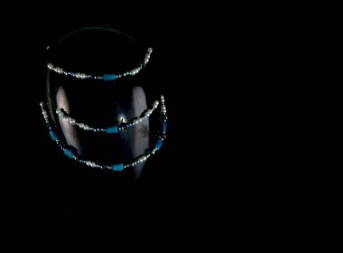 Mücevherler. Bir mankenin üzerinde el yapımı bir kolye. Portre. Koyu arkaplan