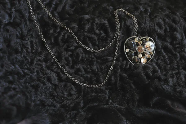 Kadınların el yapımı kolye dikkatli yapılmış. Kostüm mücevheri, yüz karası derisinin üzerinde yatar, onunla çelişir. Doğal ışık, parıltı ve yansımalar. makro