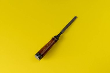 Renkli bir arka planda keski. Çalışma aracı renkli bir arkaplana karşı izole edilmiştir. Bir keski fotoğrafı. Tahta saplı bir keski.. 