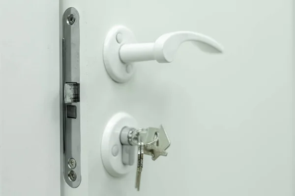 Handle, lock, lock keys and white door — Stock Photo, Image