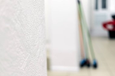 Duvarın yanında üç farklı renkte paspas duruyor.