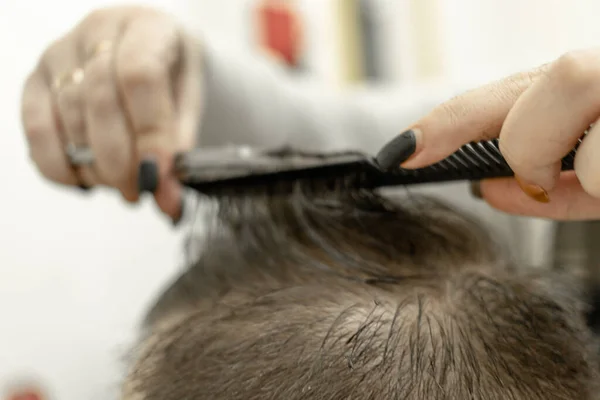 Um homem durante um corte de cabelo. mãos femininas do mestre — Fotografia de Stock