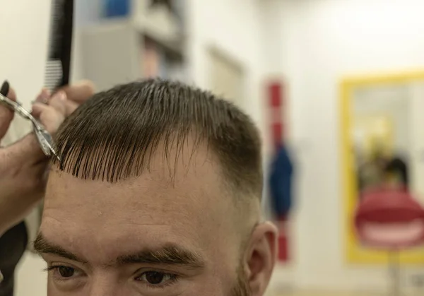 Um homem durante um corte de cabelo. mãos femininas do mestre — Fotografia de Stock