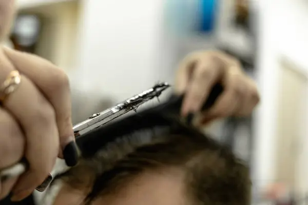 Um homem durante um corte de cabelo. mãos femininas do mestre — Fotografia de Stock