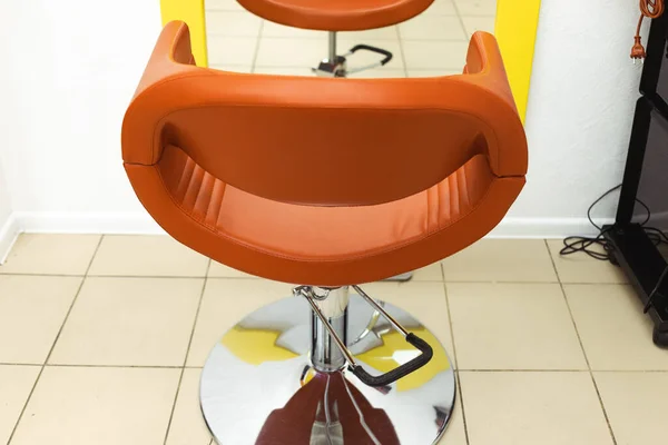 Stuhl im Friseursalon. ein schöner Schatten eines normalen Stuhls vor einem Spiegel — Stockfoto