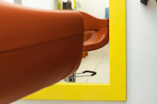 chair in the hair salon. a nice shade of a normal chair in front of a mirror