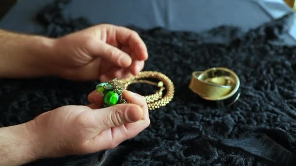 一个男人坐在桌旁拿起珠宝和珠宝 — 图库视频影像