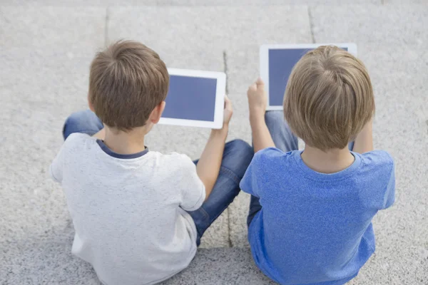 Két fiú látszó-on tabletta PC. Gyermekkor, oktatás, tanulás, technológia, szabadidő koncepció — Stock Fotó