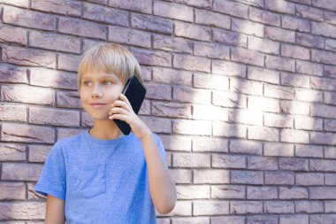 İnsanlar, teknoloji ve iletişim kavramı. Cep telefonuyla konuşurken çocuk