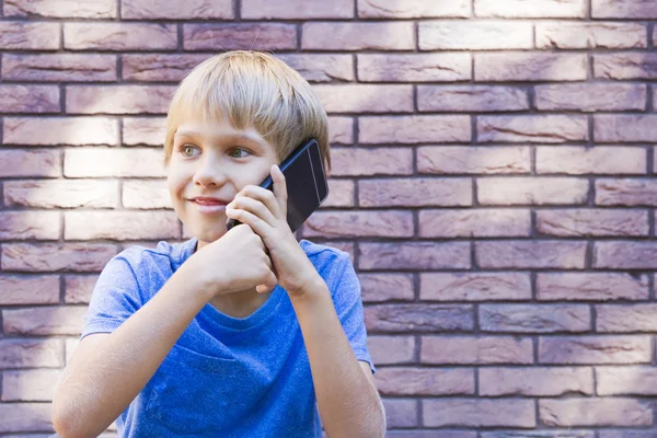 Människor, teknik och kommunikation koncept. Barnet talar i mobiltelefon — Stockfoto