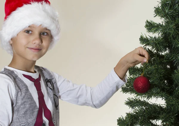 Retrato de niño feliz en Santa gorra decorando árbol de Navidad —  Fotos de Stock