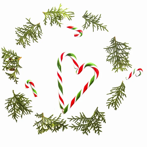 Χριστουγεννιάτικη σύνθεση. Στεφάνι φτιαγμένο από κλαδιά πράσινα thuja και καλάμους καραμελών σε άσπρο φόντο. Το Top view, επίπεδη lay. — Φωτογραφία Αρχείου