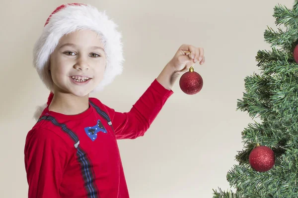 Niño feliz en Santa gorra decorando el árbol de Navidad —  Fotos de Stock