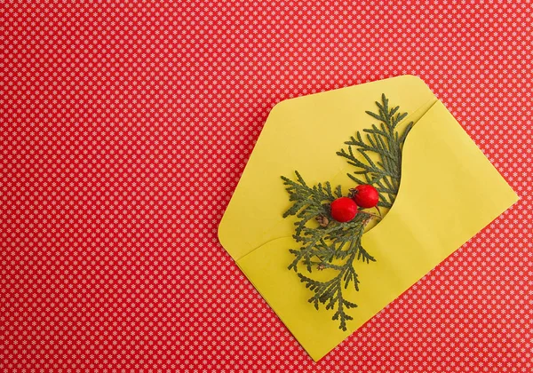 Composición navideña con sobre amarillo sobre fondo rojo. Vista superior, cama plana. De cerca. . — Foto de Stock