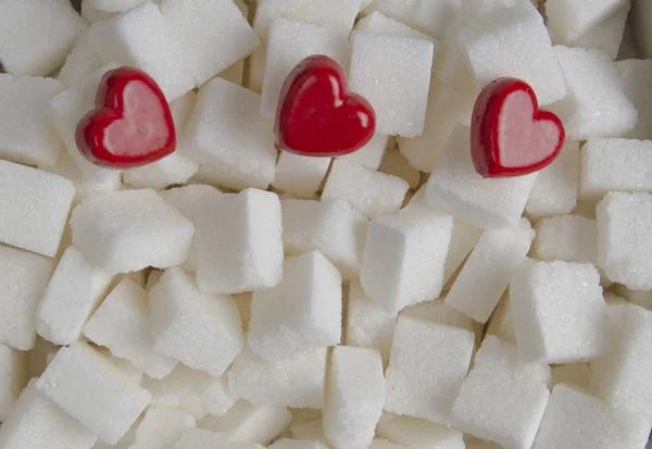 Sugar cubes with three red hearts background — Stock Photo, Image