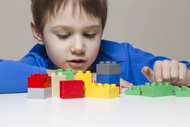 Küçük çocuk evde renkli plastik inşaat oyuncak bloklarla oynama çocuk