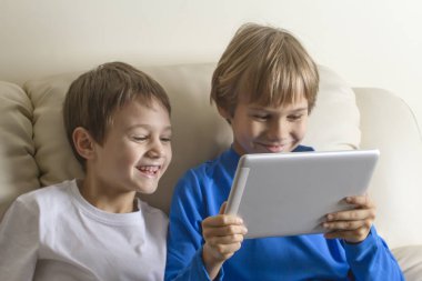 Tablet Pc. Boys ekrana bakarak, gülümseyen ve oyun oynarken veya video izlerken çocuklar. İnsanlar eğitim öğrenme teknolojisi eğlence kavramı