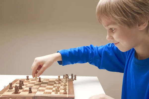 Criança sorridente jogando um jogo de xadrez — Fotografia de Stock