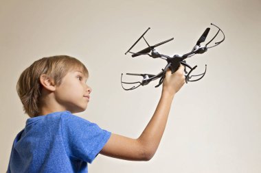 Drone ile oynayan liseli çocuk. Elinde, quadcopter tutan çocuk uçmaya hazırlanıyor