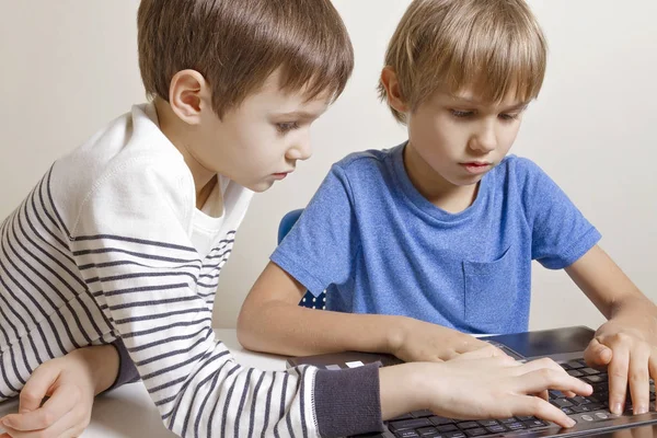 Bambini con computer portatile. Ragazzi interessati che usano il PC, guardano lo schermo, scrivono qualcosa. Persone istruzione tecnologia di apprendimento concetto di svago — Foto Stock