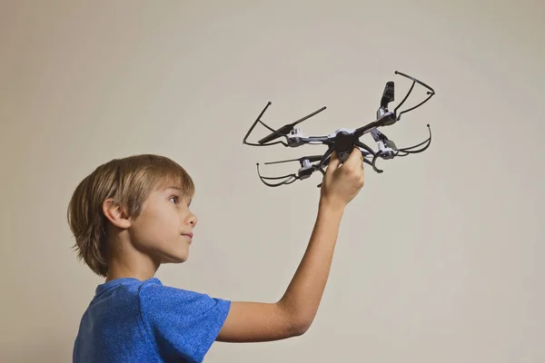 Un niño jugando con un dron. Niño sosteniendo quadcopter en su mano, preparándose para volar — Foto de Stock
