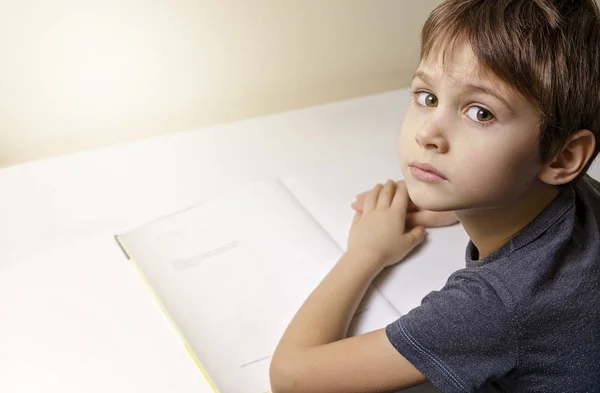 Jongetje lezen. Kind zit aan het bureau thuis. — Stockfoto