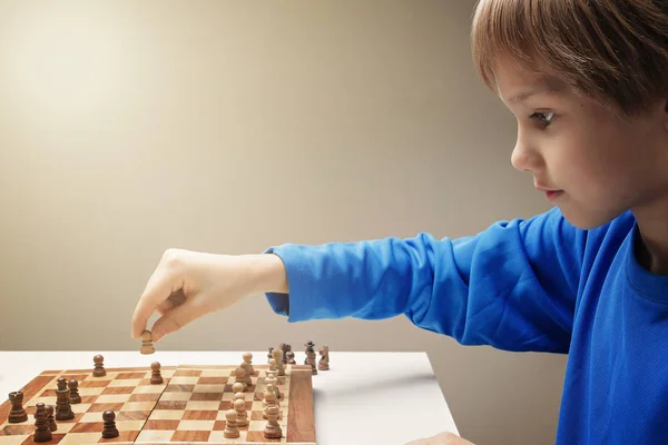 Портрет маленького кавказького хлопчика, який грає в шахи — стокове фото