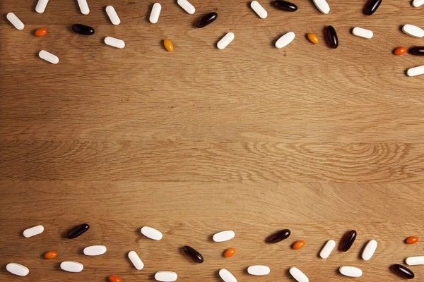 Comprimidos de fundo. Vitaminas, suplementos dietéticos, drogas, comprimidos na mesa de madeira. Conceito de farmácia, medicina e saúde . — Fotografia de Stock