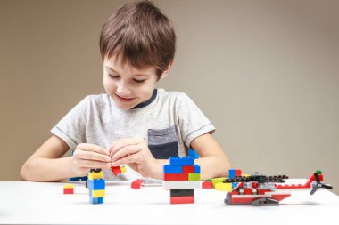 Evde renkli plastik inşaat tuğla ile oynayan küçük çocuk gülümseyen