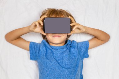 Çocuk liying 3d sanal gerçeklik, Vr mukavva gözlük ile beyaz yatakta
