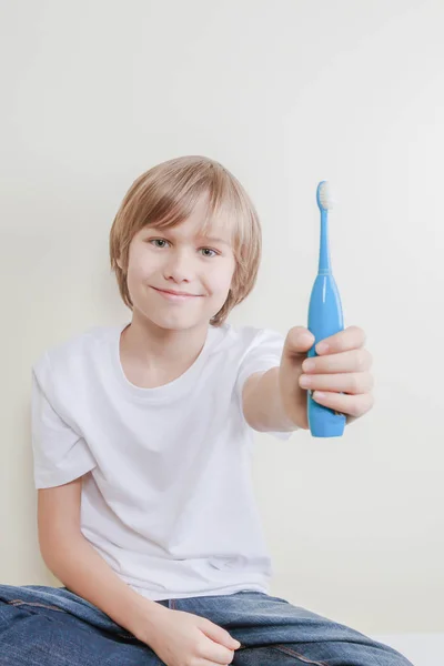 Kind stellt seine elektrische Zahnbürste aus — Stockfoto