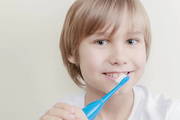 Lindo chico sonriente cepillándose los dientes con cepillo de dientes — Foto de Stock
