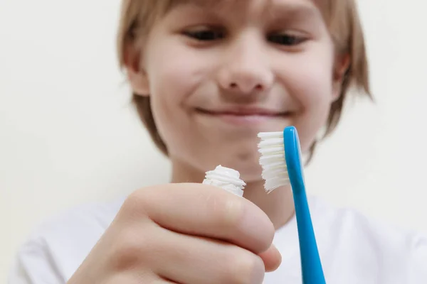 Ευτυχισμένο αγόρι λαμβάνοντας οδοντόκρεμα και ετοιμάζεται να βουρτσίζετε τα δόντια του με οδοντόβουρτσα — Φωτογραφία Αρχείου