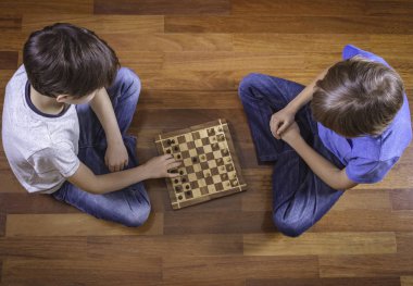 Ahşap katta oturan satranç oynayan çocuklar. Üstten Görünüm. Oyun, eğitim, yaşam tarzı, eğlence kavramı