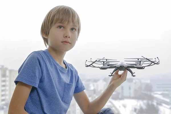 Niño con dron contra ventana en casa. Tecnología, concepto de juguetes de ocio — Foto de Stock