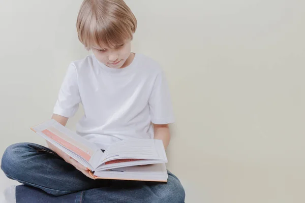 Kind lezen van een boek thuis. Onderwijs, school, vrije tijd concept. — Stockfoto