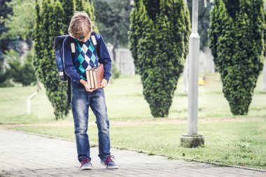 Kitap ve sırt çantası ile okul çocuğu okula git. Açık.