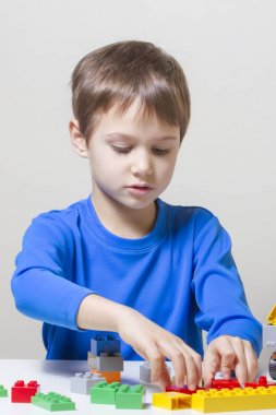 Renkli plastik inşaat tuğla ile evde oynarken küçük çocuk çocuk