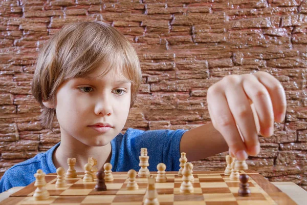 Young white child playing a game of chess on large chess board. Chess board  on table in front of school boy thinking of next move by Len44ik Vectors &  Illustrations with Unlimited