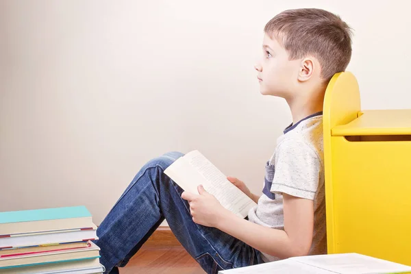 Boy čtení knihy doma. — Stock fotografie