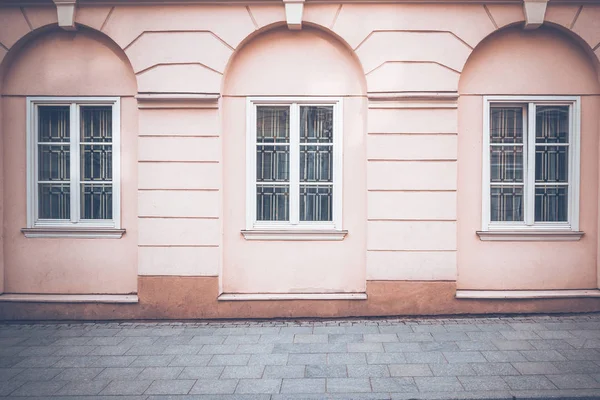 Alte klassische Hauswand mit Fenstern und Pflaster als architektonischer Hintergrund — Stockfoto