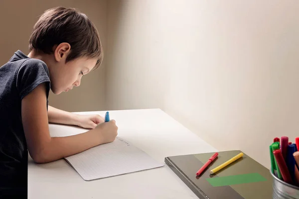 家の机に座って、彼の宿題をしている少年。児童書します。学校、子供、教育の概念 — ストック写真